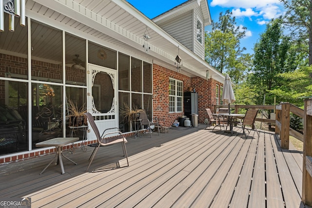 deck featuring outdoor dining area and a sunroom