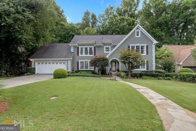 view of front of home featuring an attached garage, driveway, and a front yard