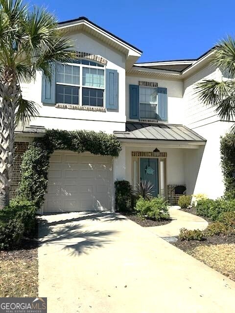 view of front of house featuring a standing seam roof, metal roof, driveway, a garage, and stucco siding