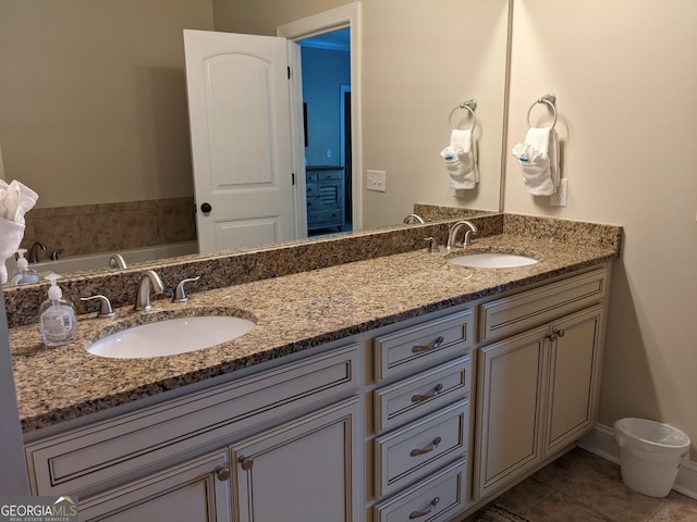 bathroom featuring a sink, tile patterned flooring, a bathtub, and double vanity