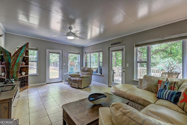 living area featuring crown molding, baseboards, light tile patterned flooring, and a wealth of natural light