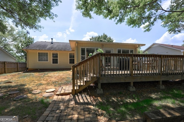 back of property with fence and a deck