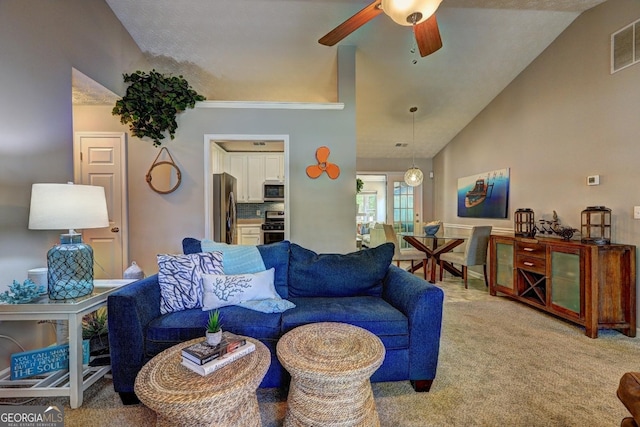 living room featuring vaulted ceiling, carpet, a ceiling fan, and visible vents