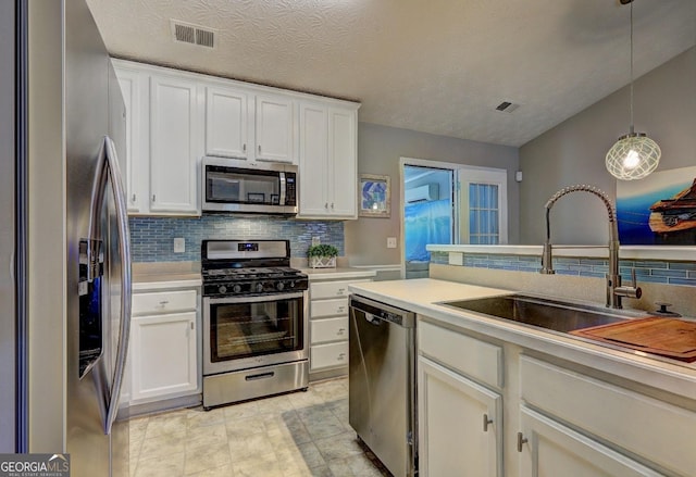 kitchen featuring visible vents, light countertops, a sink, appliances with stainless steel finishes, and backsplash