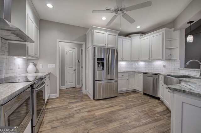 57 Round Rock Cir NE, Rome, GA 30161 - kitchen featuring a sink, wall chimney exhaust hood, stainless steel appliances, a ceiling fan, and white cabinetry