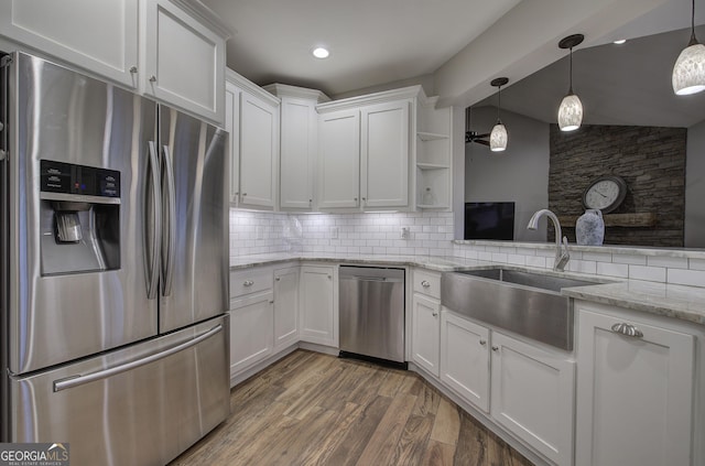 57 Round Rock Cir NE, Rome, GA 30161 - kitchen with decorative backsplash, white cabinetry, a sink, light wood finished floors, and stainless steel appliances