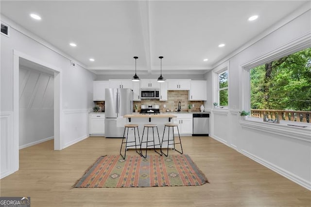 1839 Belcher Pl, Austell, GA 30168 - kitchen featuring a kitchen island, light wood-style floors, white cabinetry, tasteful backsplash, and appliances with stainless steel finishes