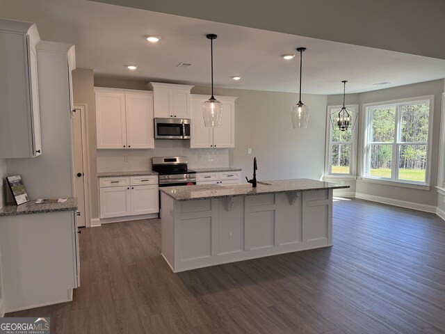788 Traveler Ln, Williamson, GA 30292 - kitchen with decorative backsplash, light stone counters, dark wood-style floors, stainless steel appliances, and white cabinetry