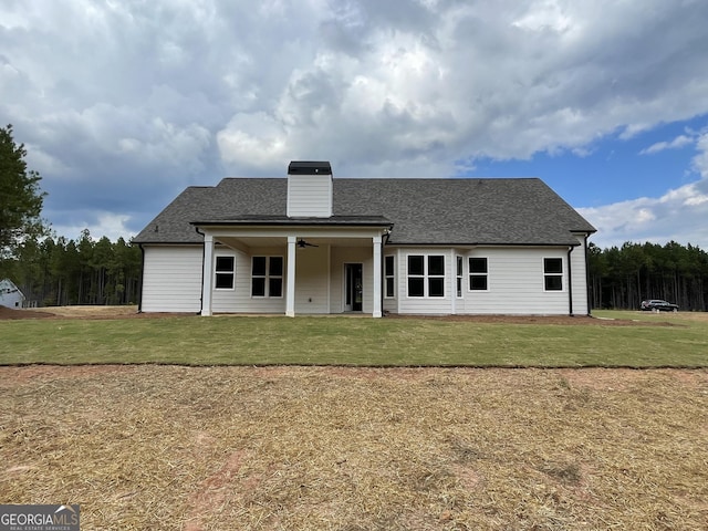 788 Traveler Ln, Williamson, GA 30292 - back of property featuring a yard, ceiling fan, a shingled roof, and a chimney