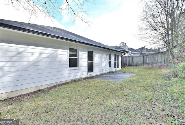 rear view of house with a yard, a patio area, and fence