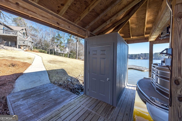 wooden terrace featuring a water view and a boat dock