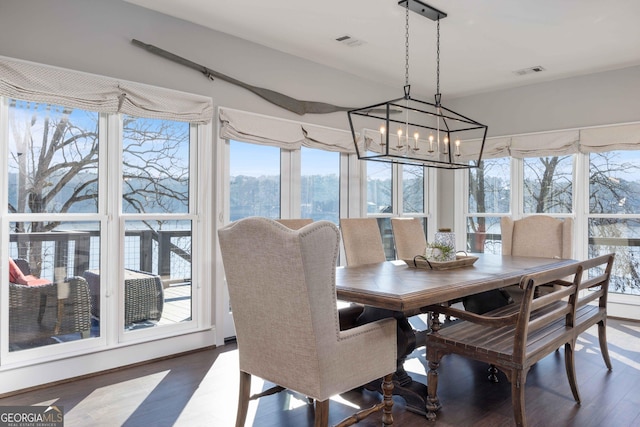 dining space featuring an inviting chandelier, visible vents, and wood finished floors