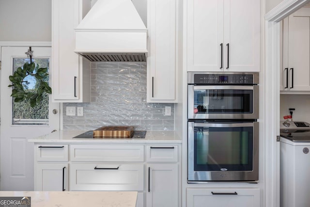 302 Odom Dr, Hamilton, GA 31811 - kitchen featuring premium range hood, washer / dryer, stainless steel double oven, black electric stovetop, and backsplash