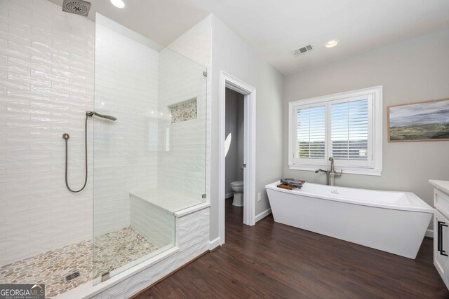 302 Odom Dr, Hamilton, GA 31811 - bathroom with tiled shower, toilet, wood finished floors, a soaking tub, and baseboards
