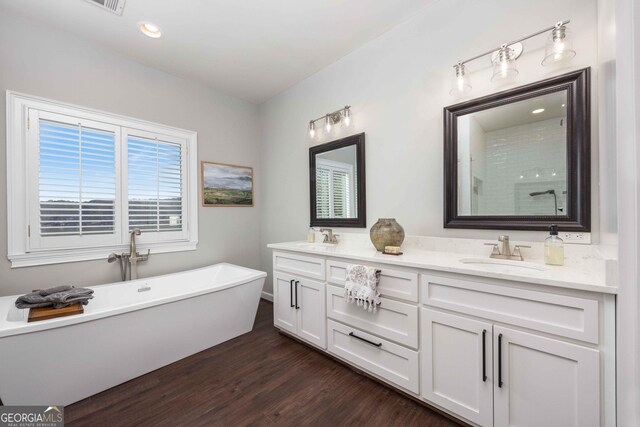 302 Odom Dr, Hamilton, GA 31811 - bathroom featuring wood finished floors, double vanity, a freestanding bath, a shower, and recessed lighting