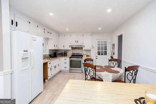 4812 Pamela Ct, Acworth, GA 30101 - kitchen featuring white cabinets, stainless steel stove, white fridge with ice dispenser, backsplash, and under cabinet range hood