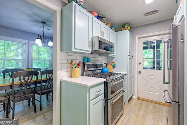 kitchen featuring stainless steel appliances, light wood-type flooring, and healthy amount of natural light