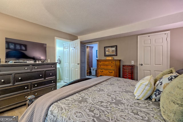 bedroom featuring a closet, a textured ceiling, and wood finished floors