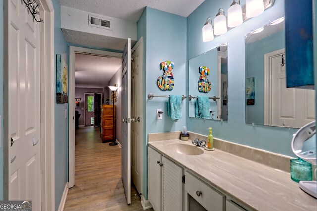 bathroom featuring wood finished floors, vanity, and baseboards