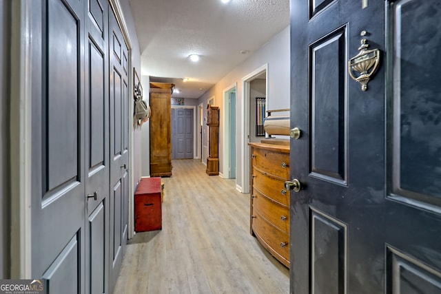entrance foyer with light wood-style flooring and a textured ceiling