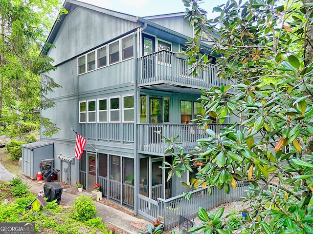 rear view of property with a balcony and a sunroom