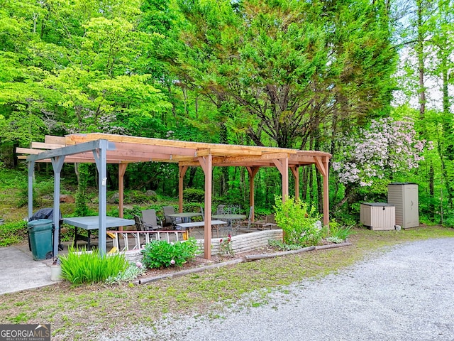surrounding community featuring a pergola and a forest view