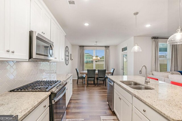112 Leveret Rd, Locust Grove, GA 30248 - kitchen featuring decorative backsplash, dark wood-type flooring, white cabinetry, a sink, and stainless steel appliances