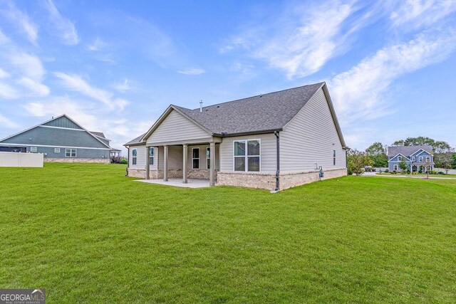 112 Leveret Rd, Locust Grove, GA 30248 - rear view of house with a lawn, a patio area, roof with shingles, and stone siding