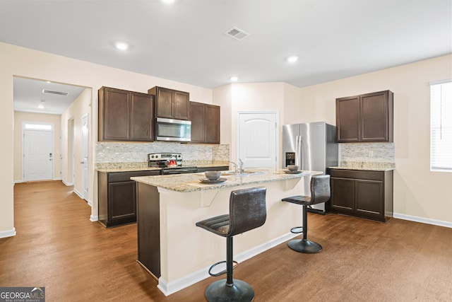 138 Yonah Way, Dallas, GA 30132 - kitchen featuring appliances with stainless steel finishes, dark brown cabinets, decorative backsplash, a breakfast bar area, and recessed lighting
