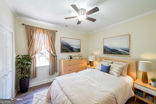 bedroom featuring wood finished floors, ornamental molding, baseboards, and ceiling fan