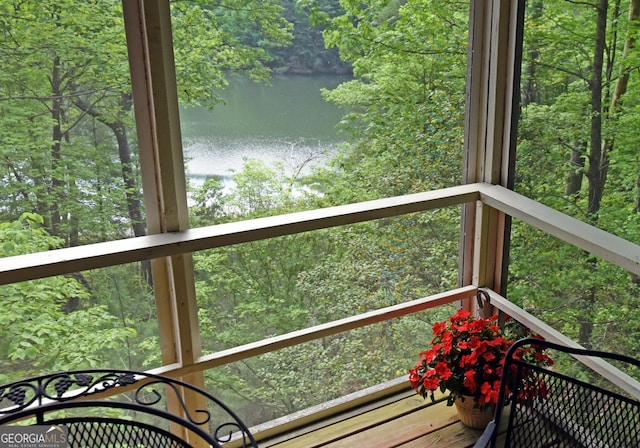 wooden terrace with a water view and a forest view