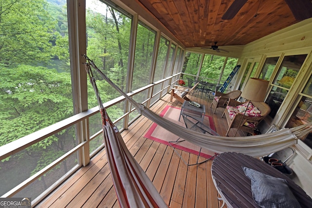 sunroom / solarium featuring a ceiling fan