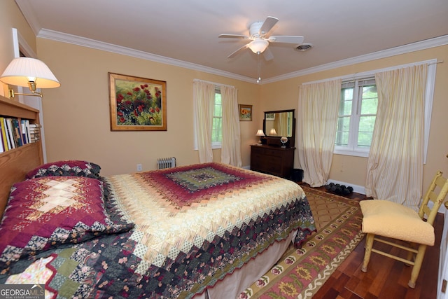bedroom with visible vents, ornamental molding, baseboards, and wood finished floors