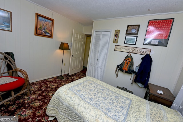 bedroom featuring crown molding, a closet, baseboards, a textured ceiling, and carpet flooring