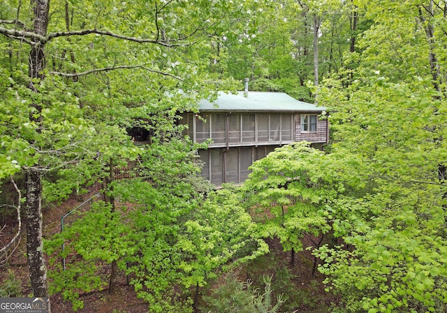 view of side of home featuring a view of trees