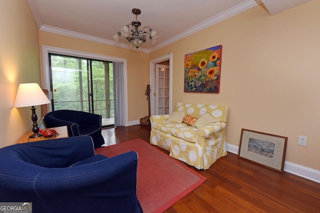 living area with crown molding, baseboards, an inviting chandelier, and wood finished floors