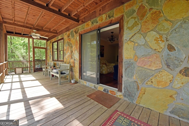 unfurnished sunroom featuring ceiling fan and beam ceiling