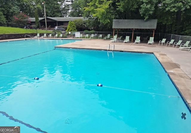 community pool featuring fence and a patio area
