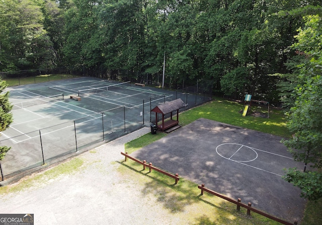view of sport court featuring a yard, fence, and playground community