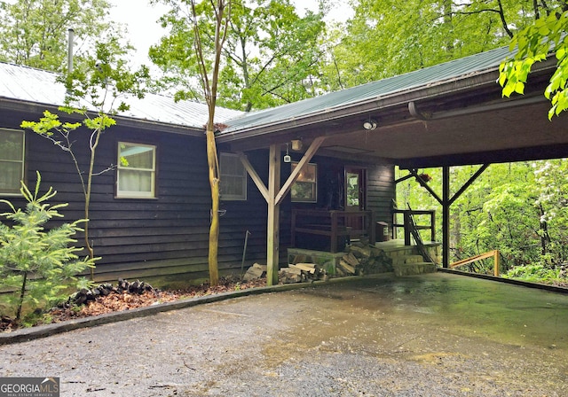 view of side of property featuring a carport, covered porch, and metal roof
