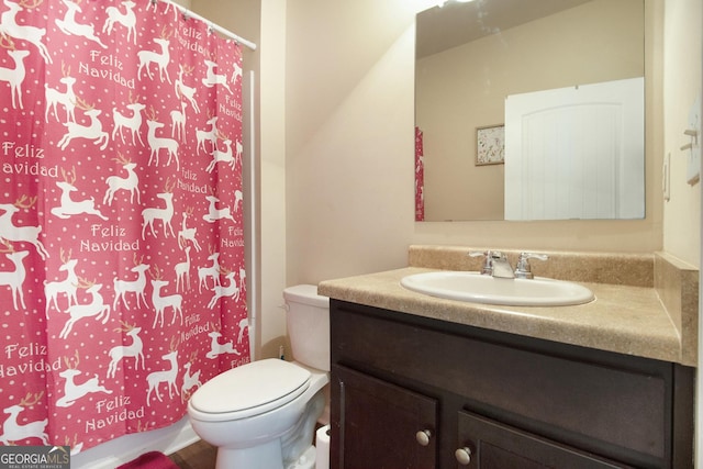 full bath featuring vanity, toilet, and curtained shower