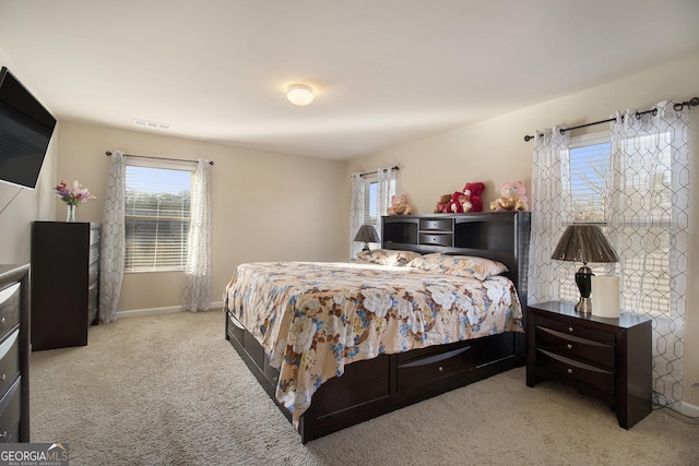 carpeted bedroom featuring baseboards, multiple windows, and visible vents