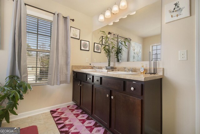 bathroom with double vanity, baseboards, and a sink