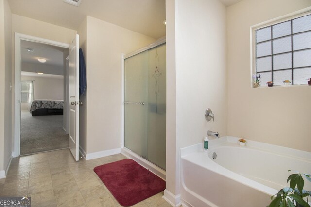 ensuite bathroom with a garden tub, connected bathroom, baseboards, and a stall shower