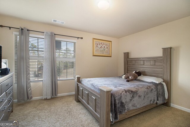 bedroom featuring visible vents, baseboards, and light carpet