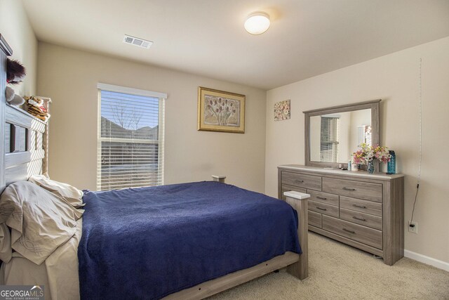 bedroom featuring baseboards, visible vents, and light carpet