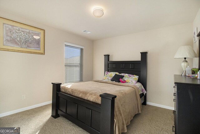 bedroom featuring baseboards, visible vents, and light colored carpet