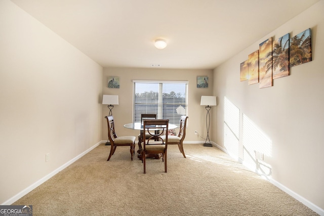 dining room featuring baseboards, visible vents, and light carpet