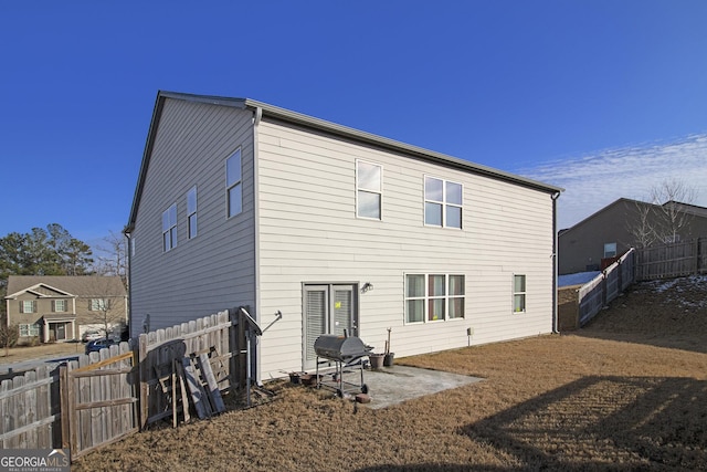 rear view of property with a patio and a fenced backyard