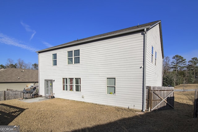 rear view of house featuring a patio and fence